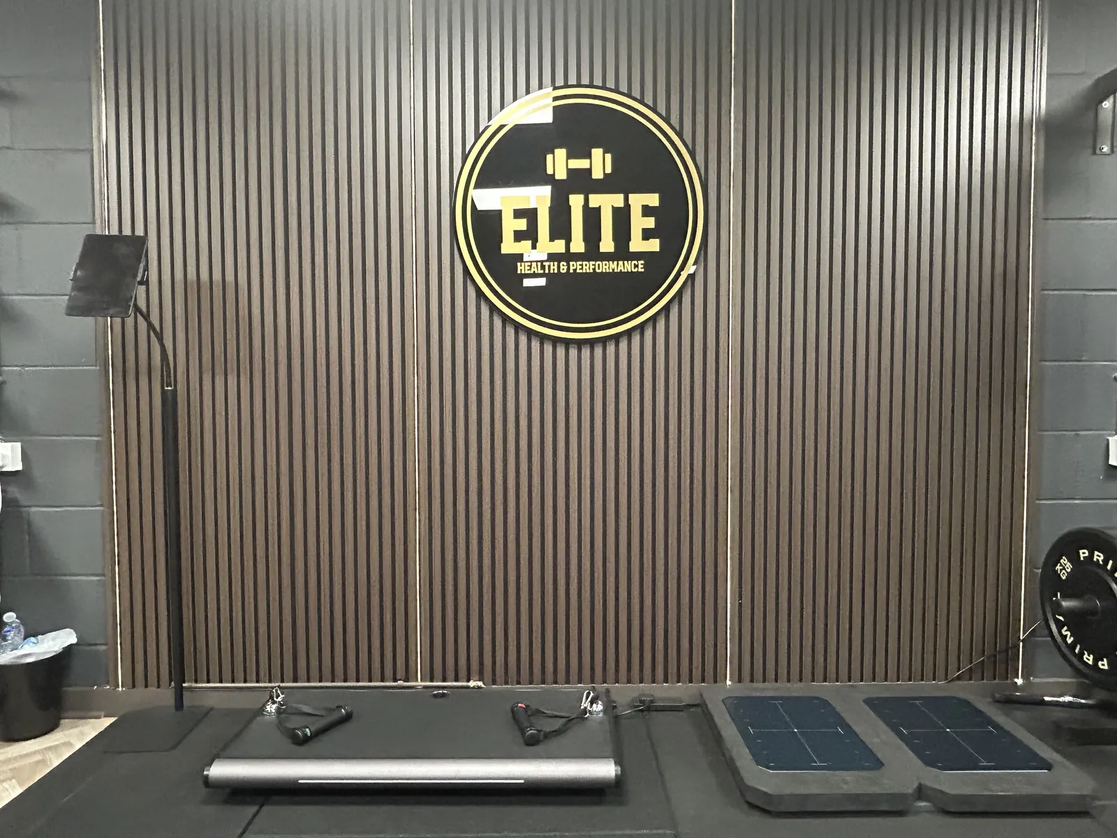 Force plates in front of the Elite Health & Performance logo wall